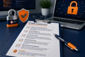 Cyber Essentials checklist on clipboard with padlock, shield and laptop lock icon, cybersecurity compliance concept.